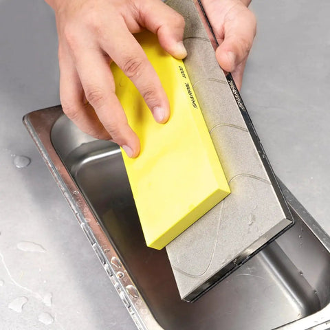 Hands holding a yellow whetstone against an Extra Coarse 220 Grit Diamond Lapping Plate 10 X 4 Inch for flattening sharpening stones.