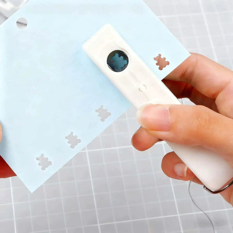 One-Handed 2mm Circle Pattern Embosser With Built-In Waste Storage, Easy-Squeeze Punch Tool in use on blue paper, Sky Blue.