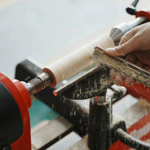 Four Prong Spring Loaded Spur Drive Center For 2MT Wood Lathe in use turning a wooden piece with one inch diameter and spring retracting center pin.