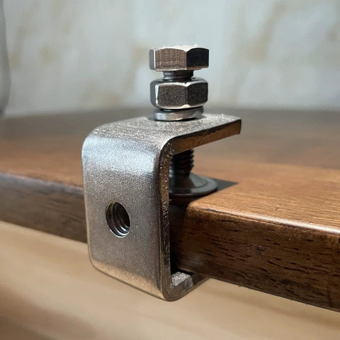 C-clamp, 1-inch stainless steel woodworking clamp with wide jaw, mounted on a wooden edge.