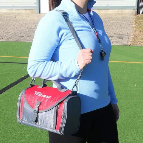 Person holding All In One Sports Coach First Aid Kit In A Durable Duffel Bag With 189 Pieces For Basketball Baseball Football Volleyball Soccer