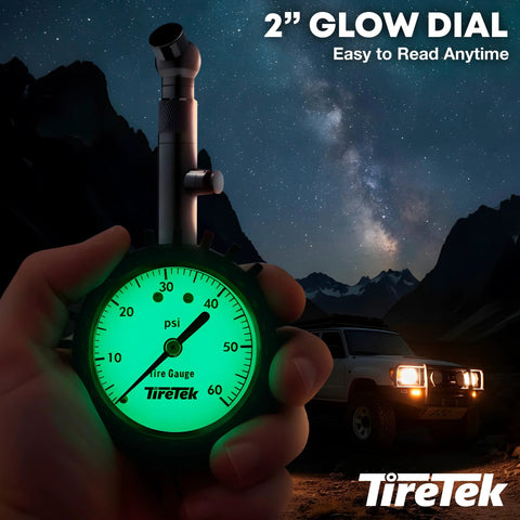 Automotive tire pressure gauge with a glowing green 2-inch dial showing psi, held in hand; TireTek logo visible at night.