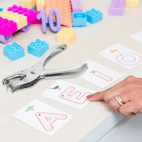 Dope 20 Pack One Quarter Inch Single Hole Punch Set, Metal Hand Paper Puncher on a desk with alphabet cards and colorful blocks