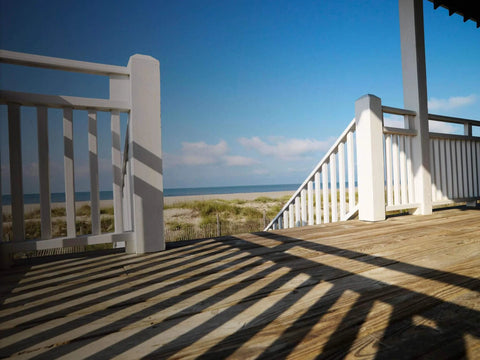 Wooden deck overlooking beach, showcasing deck built with DSVT4MB Deck-Drive DSV Wood Screw 10 x 4 Inch Flat Head T-25.