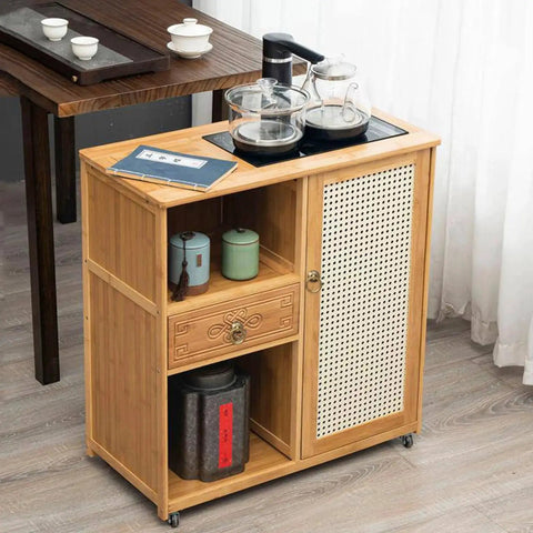 Wooden tea cabinet with glass teapots, cups, and drawer, featuring intricate design in a modern kitchen setting.