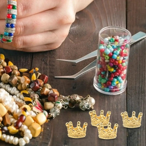 Crafting tools with Dope Vintage Style Crown Charms Set, 50 Pcs Alloy Gold Tone Crown Pendants, beads, and bracelets on a table