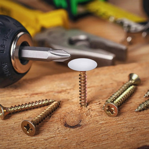 Plastic Self Tapping and Self Adhesive Screw Hole Covers for Wood Furniture, white cap on screw in wooden surface with tools nearby.