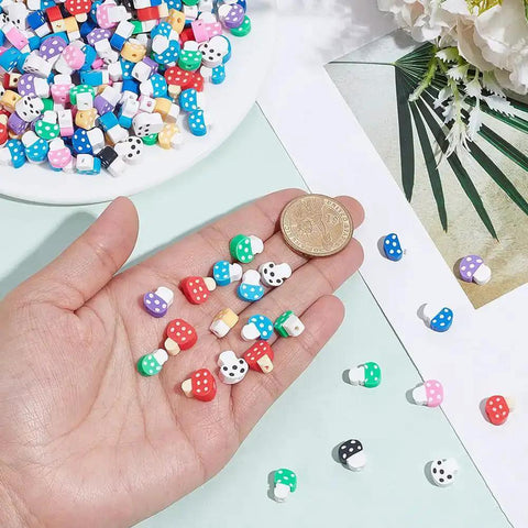 Hand holding polymer clay mushroom beads with 400 mixed color beads, handmade mushroom shapes, vegetable theme spacer charms.
