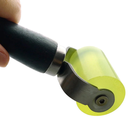 Car sound deadener application roller tool with a bright yellow-green, translucent wheel and black handle for cars.