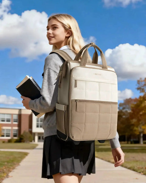 Young woman outdoors carrying a beige and white backpack, smiling and holding books against a backdrop of a school building and blue sky.