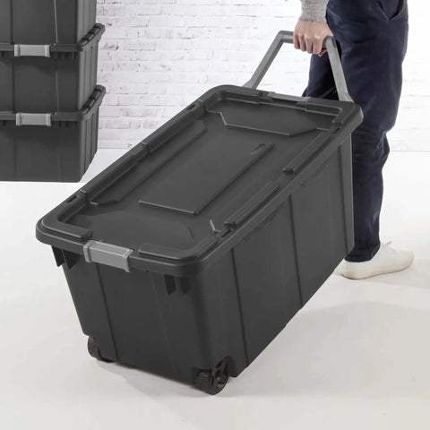 Person rolling Beefy 40 Gallon Storage Bin On Wheels With Locking Lid Resin Plastic Toolbox For Garage, deep gray