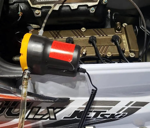 Portable 12V 60W Oil Extractor Pump For Fluid Changes shown in use on a jet ski engine, illustrating the grab-and-go design.