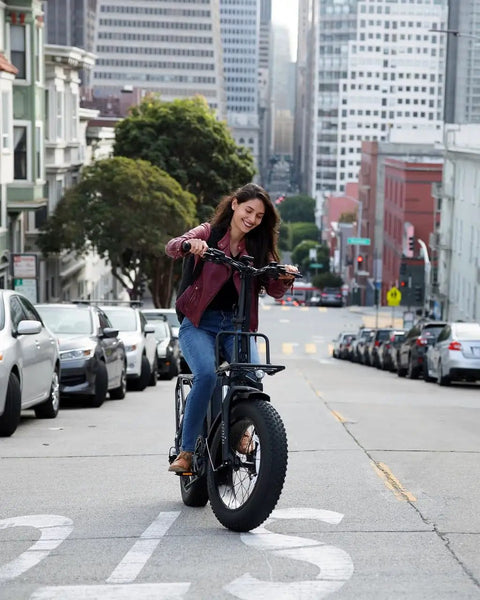 Electric bike with hydraulic disc brakes; side view of a black fat-tire bike ridden on an urban street.