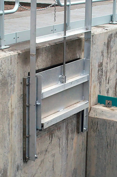 Metal sliding gate mechanism installed on a concrete wall, showcasing heavy-duty steel construction for water flow control or regulation.