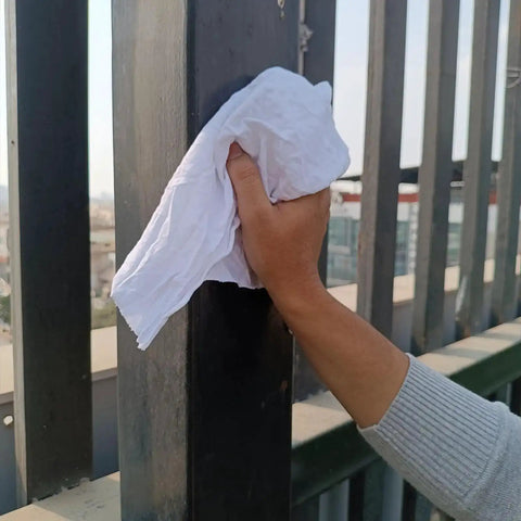 Hand using Heavy Duty Recycled White T Shirt Cleaning Rags 10 Lbs Bag Bulk Multipurpose Shop Towels For Oil Grease Paint Stain Cleanup