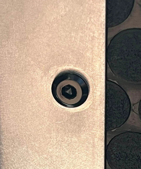 Close-up of a black M6 flat head Allen bolt installed in furniture, part of a 12 Pack M6 22mm Black Flat Head Allen Bolts For Furniture And Home Office Tables Desks Cabinets Wardrobes Made From 304 Stainless Steel Rust Resistant Heavy Duty Socket Cap Screws Built Tough set.