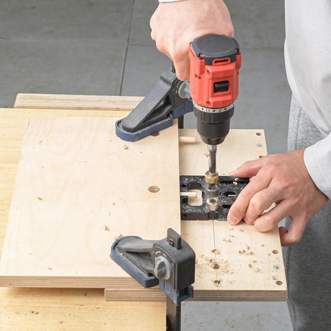 Person using Beefy Aluminum Doweling Jig Self Centering Drill Guide Kit With 6mm 8mm 10mm Drill Bits And 12mm Eccentric Wheel for woodworking.