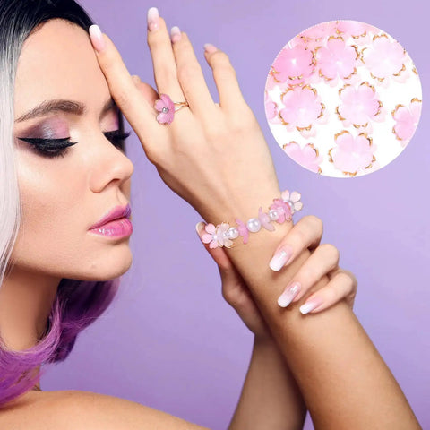 Model wearing bracelet with Pink Gradient Cherry Blossom Bead Set, 100 Pcs 5-Petal Acrylic Flower Beads, jewelry making focus.