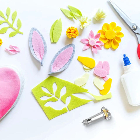 Craft materials including felt flowers and leaves, scissors, glue, German Tungsten Carbide Knife Blade 12 Mm With Drive Housing And Silicone Protective Cover For Maker 3 And Maker 4 Laser Cutter Ideal For Wood Cutting Mat Board Chipboard Leather And More Great Replacement Part For Models Puzzles And Leather Goods, and pink fabric scraps displayed on a table.