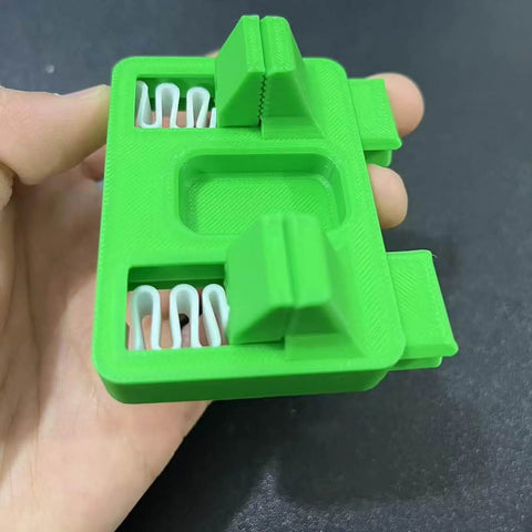 Green nonslip adjustable soldering aid clamp fixture for precise wire welding and soldering jigs, held in hand, side view.