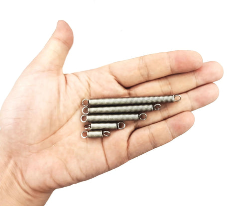 Six stainless steel extension springs with loop hooks held in hand