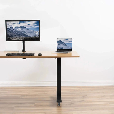 Standing desk with one and a half inch swivel caster wheels with brakes for mobile use, featuring a computer setup.