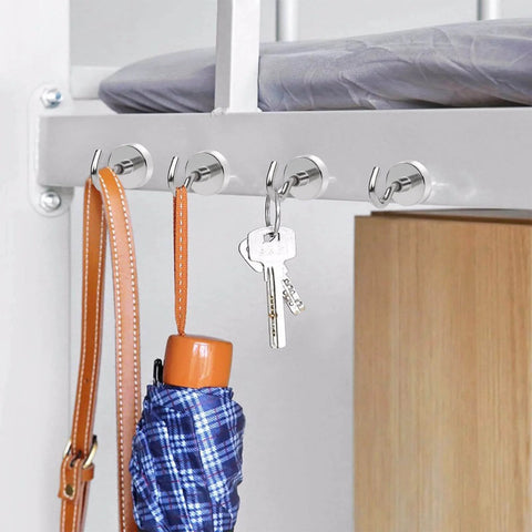 Magnetic hooks holding a bag, keys, and an umbrella under a metal frame, showcasing utility organization with simple installation.