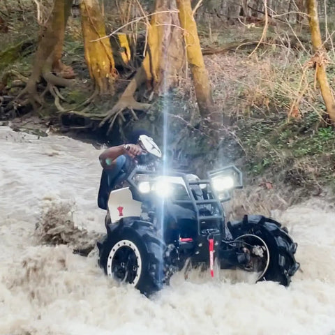 Beefed Up Heavy Duty 2500 Lb 12V ATV UTV Winch With Waterproof Electric Motor Three Sixteenth Inch By 32 Foot Synthetic Rope Wireless Remote And Mounting Plate For Off Road Towing By OpenRoad, installed on ATV in water.