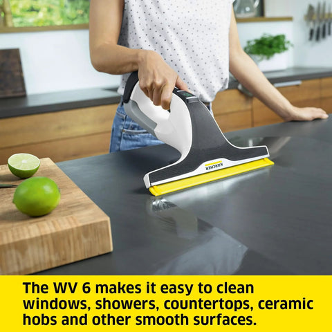 Kärcher WV 6 electric window vacuum squeegee on kitchen counter; white gray handheld with yellow 11-inch blade.