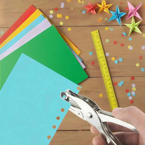 Person using metal handheld craft puncher on colored paper with confetti, 36 Pack One Quarter Inch Single Hole Punch Kit, ruler nearby