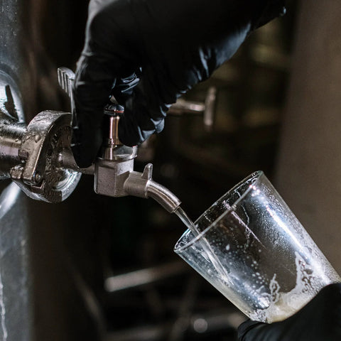 DERNORD stainless beer sampling valve with 1.5-inch tri-clamp end dispensing into glass.