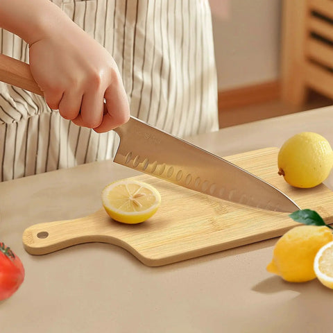 Person slicing a lemon on a bamboo cutting board with handle. Bulk 50 Pieces Bamboo Cutting Board With Handle For Laser Engraving Serving Board Charcuterie Tray 11 Inch By 5 Inch Ideal Gift For Mothers Day Housewarming Personalize On Blank Surface.