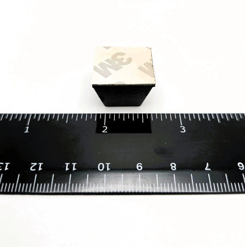 Close-up of adhesive-backed Three Quarters Inch Wide Pyramid Silicone Rubber Bumper Feet with ruler for size reference.