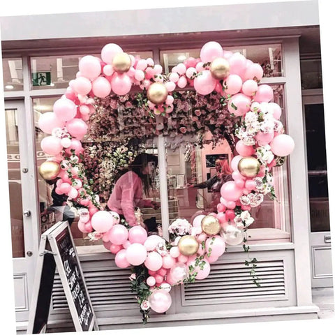 Balloon heart-shaped arch made of pink and gold balloons as part of a wedding display, showing the use of a Balloon Arch Stand Kit For Weddings And Parties, Flexible, Reusable Poles.