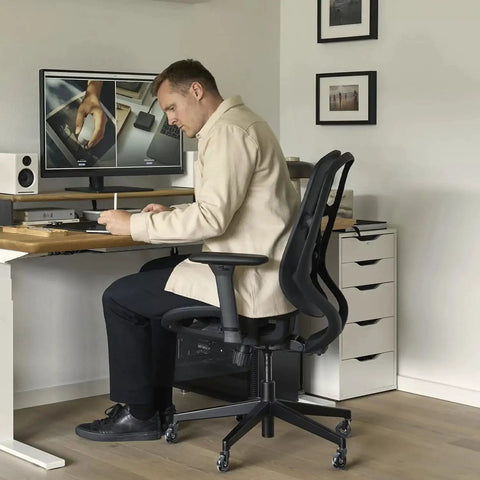 Man sitting on an office chair with installed Office Chair Wheel Replacement Set Of 5 11x22mm 3 Inch Black Polyurethane Casters.
