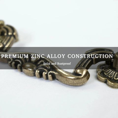 Close-up of antique brass drop bail pull showing vintage floral design and zinc alloy material, part of Six Pack Antique Brass Drop Bail Pulls With Vintage Floral Base Plates For Cabinets Dressers And Wardrobes And Cupboards 3 Inch Hole Centers 76mm Classic Decorative Hardware For Furniture Renovation.