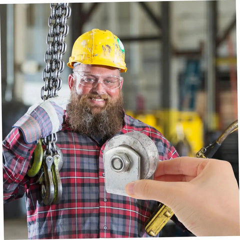 Worker holding a steel roller in a workshop environment, showcasing its use in heavy-duty industrial pulley systems