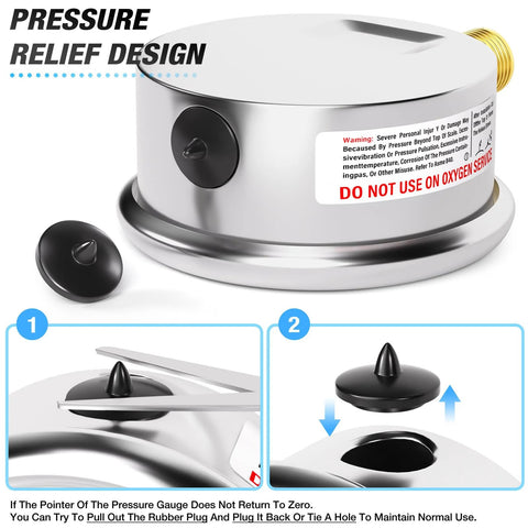Polished stainless steel pressure gauge housing with brass inlet and black end caps; warning label visible.