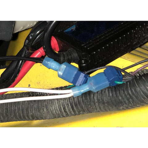 Blue insulated automotive quick-disconnect terminals (T-tap) connected to white wires in a vehicle wiring harness.
