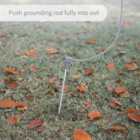 Outdoor Grounding Rod Kit with 40FT Conductive Cord Copper Earthing Stake inserted into soil with fallen leaves