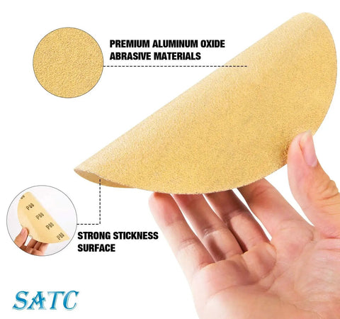 Hand holding 100 Pack 6 Inch 80 Grit Adhesive Backed Sanding Discs Aluminum Oxide For Drill showing abrasive and adhesive surface
