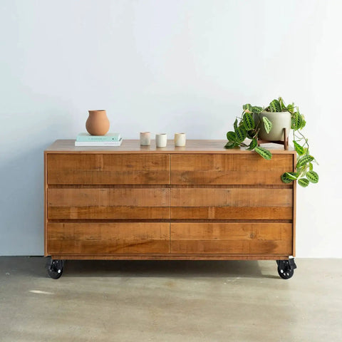 Wooden dresser on casters with a plant on top, featuring Three Inch Plate Caster Wheel Set With Cast Iron Swivel Plate Casters And Dual Locking.