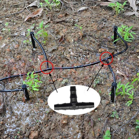 Barbed irrigation fittings kit for 1/4 in tubing; black plastic tees, elbows and end plugs shown on soil with inset of a T-connector.