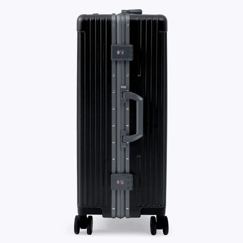 Side view of jet black zipperless check-in suitcase with aluminum frame and polycarbonate shell, TSA locks, by Nobl Travel.