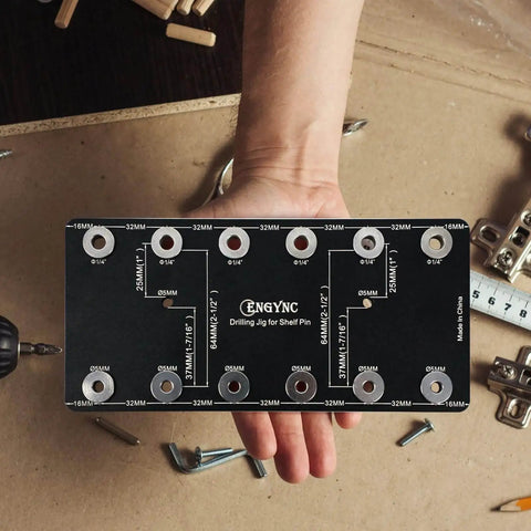 Person holding Aluminum Shelf Pin Drilling Jig for One Quarter Inch and Five Millimeter Holes on wooden workspace