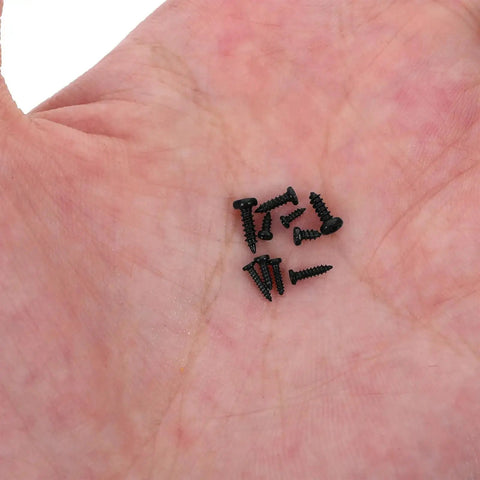 Close-up of small black screws in hand, part of the 1000 Pieces Self Tapping Screws Set Round Head Small Screws For Electronics Car Models And DIY Projects Portable Industrial Hardware Kit For Micro Electronics And Machinery Assembly Heavy Duty Pro Grade.