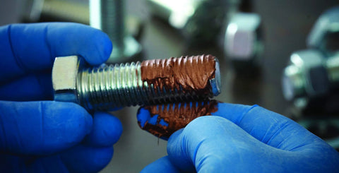 Extreme Temperature Copper Grease For High Heat Up To 2012 Degrees Fahrenheit applied on a bolt to prevent seizing and galling.