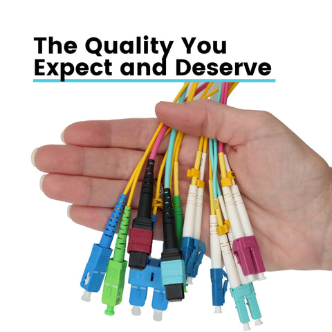 Hand holding multiple LC to LC OM4 fiber patch cables, duplex multimode 50/125µm, assorted color boots.