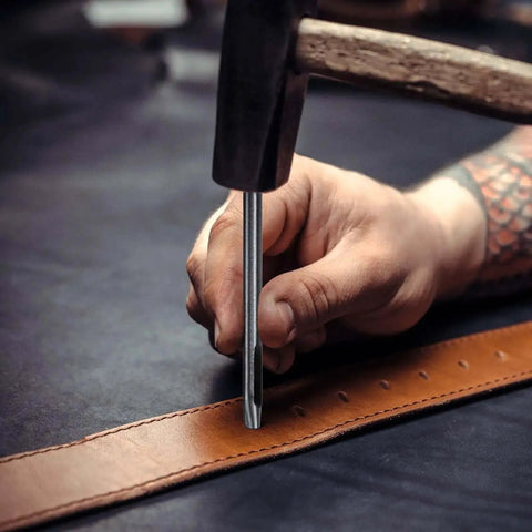 Using Leather Oval Hole Punch 6x5mm Belt Hole Puncher on leather strap with a hammer, precision cutting.