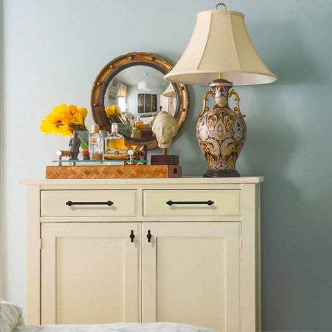 Room with a lamp, mirror, flowers, and a decorated cabinet with Oil Rubbed Bronze Cabinet Knobs Set, 10 Pack, 1 Inch 25mm For Cabinets And Drawers, Kitchen Cabinet Hardware And Dresser Knobs, Rust Proof Zinc Alloy With Matte Finish And Scratch Resistant CK0081 By Coinkoly